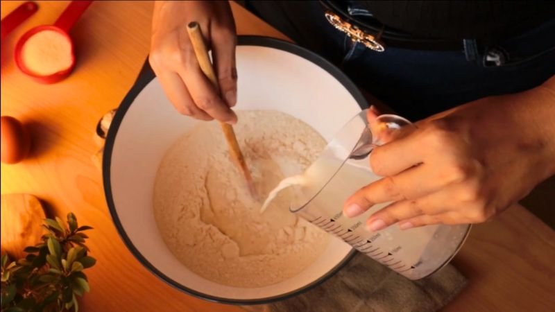 mezclando-masa-pan-manzana Preparación de la masa para el pan dulce de manzana y queso crema: vertiendo la leche tibia en el bol con harina.