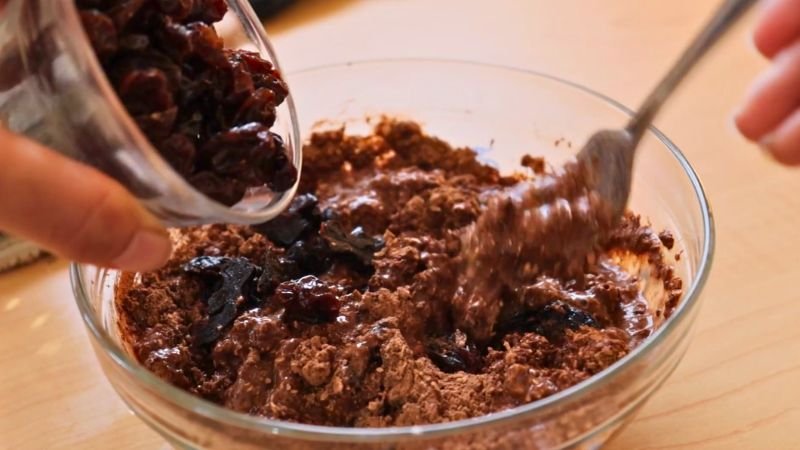 frutos-secos-cupcakes-saludables-avena.jpg Agregando pasas y ciruelas pasas a la mezcla de cupcakes saludables de avena y chocolate.