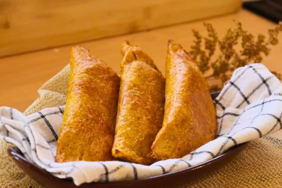 Comidas Saludables Empanadas de auyama saludables sin harina de trigo rellenas de pollo, servidas en una cesta con servilleta de cuadros.