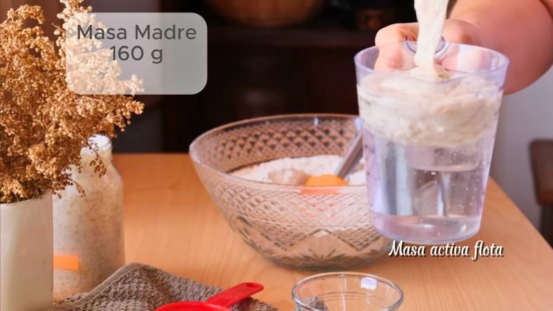 paso-a-paso-pan-integral-masa-madre-coffee-maria Mezcla de harina integral y masa madre en un bol de cristal, proceso de elaboración de pan artesanal paso a paso.