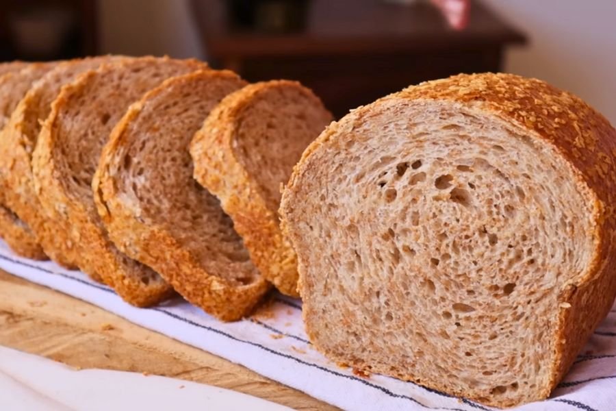 Postres & Panadería Rebanadas de pan integral de masa madre fácil y crujiente con miga esponjosa sobre un paño de cocina.