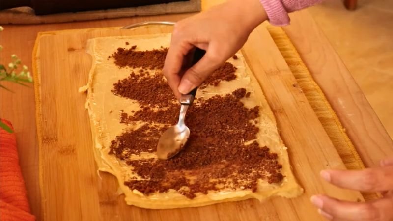 Esparciendo el relleno de papelón y especias sobre la masa de los golfeados - Coffee María