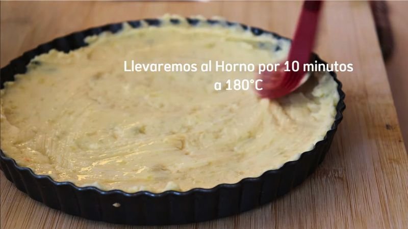 Primer horneado de la base - Coffee María. Masa de papa extendida uniformemente en un molde circular negro antes de entrar al horno a 180°C.