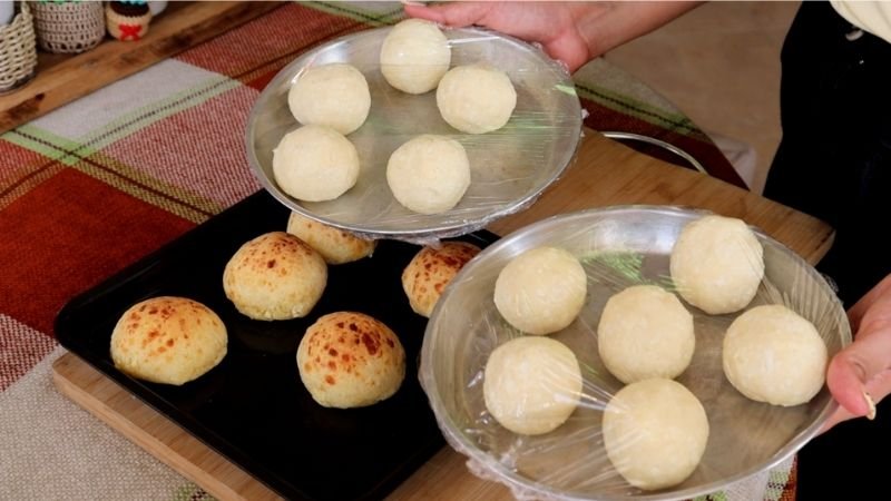 Bandejas con bolitas de pão de queijo tradicional listas para congelar y porciones horneadas.