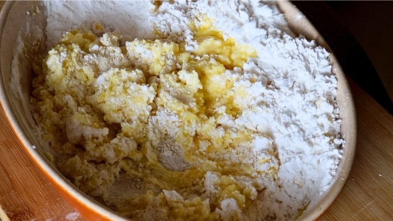Integrando los líquidos hirviendo con el almidón en el bol para mi receta de pão de queijo tradicional.