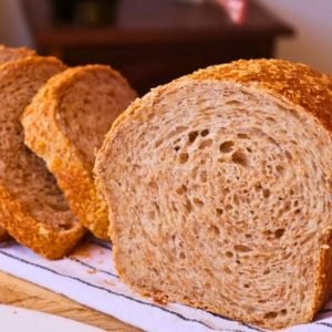 Rebanadas de pan integral de masa madre casero con miga alveolada expuesta sobre un paño de cocina, mostrando la textura rústica y esponjosa.